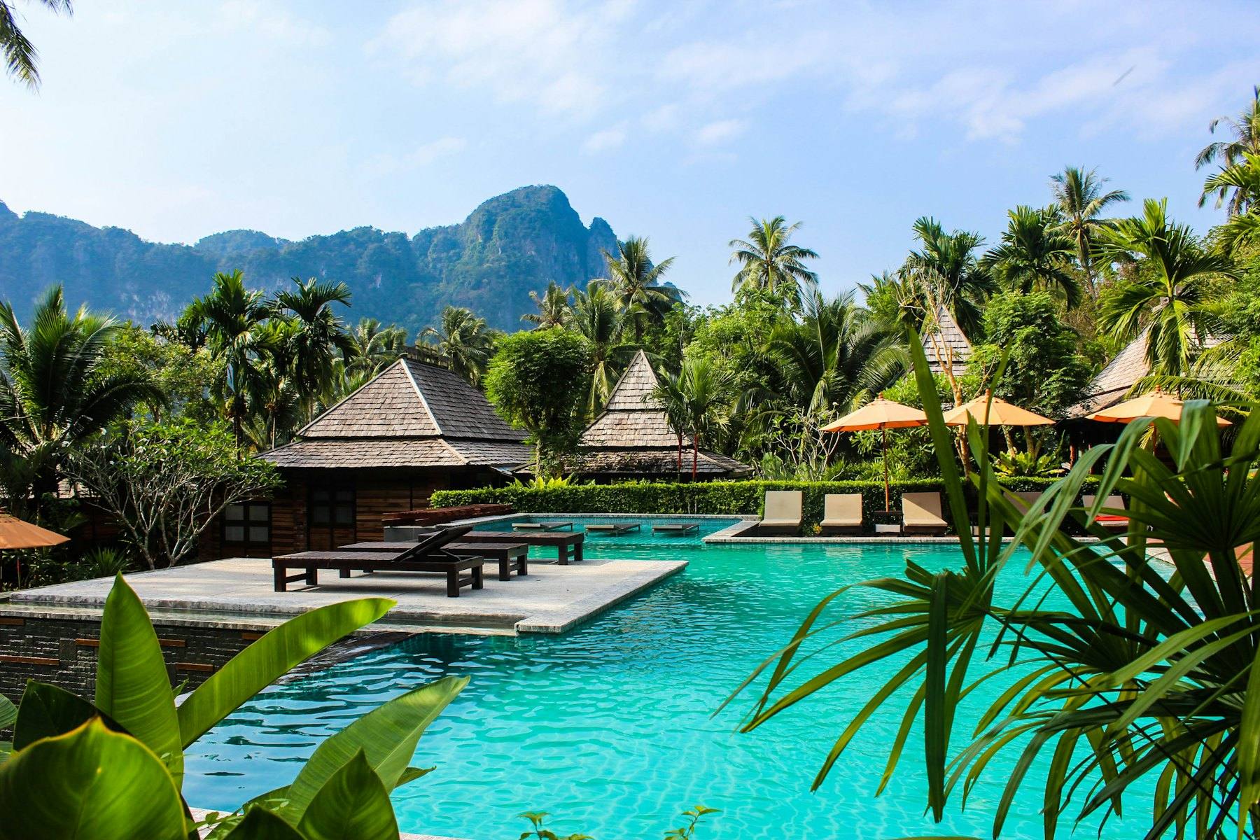 A pool among tropical gardens with mountains behind